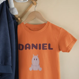  Orange children's T-shirt printed with the name Daniel and a drawing of a baby hippopotamus